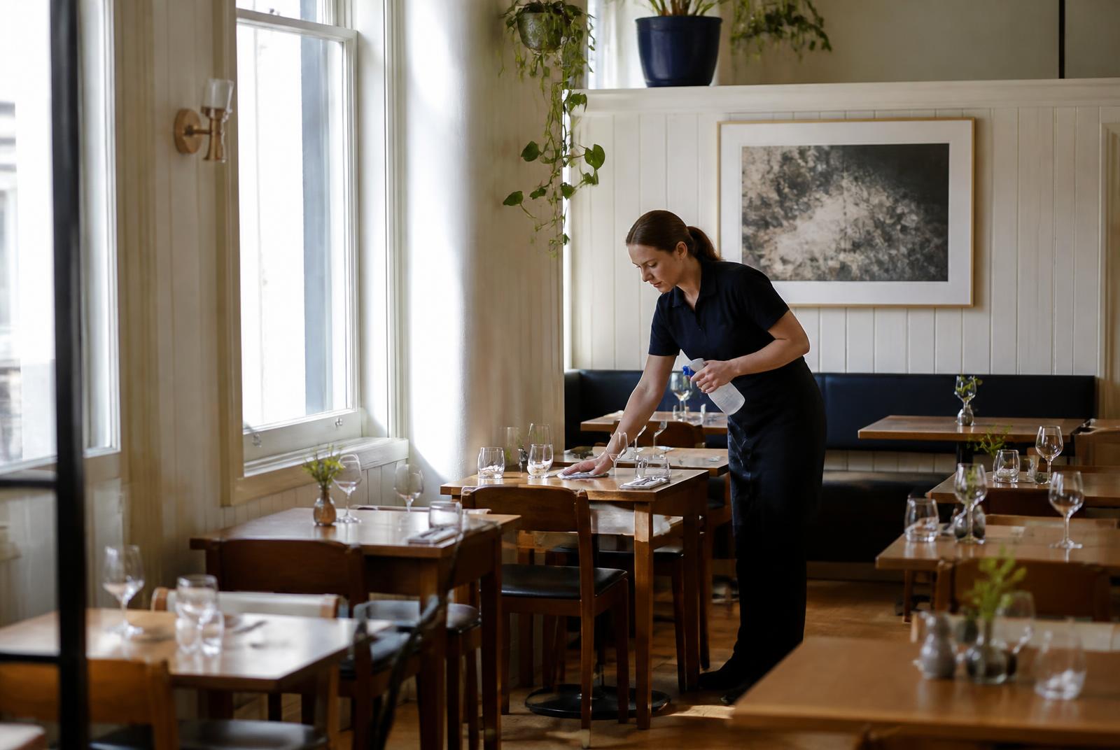 Cleaner preparing a restaurant before customers arrive
